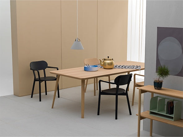 Butacas Castor Armchair Plus negras alrededor de una mesa de roble, aparador bajo de roble