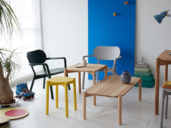 Hocker Castor Plus in Gelb vor einer blauen Wand, mit Sesseln Castor und Couchtisch | Antifer
