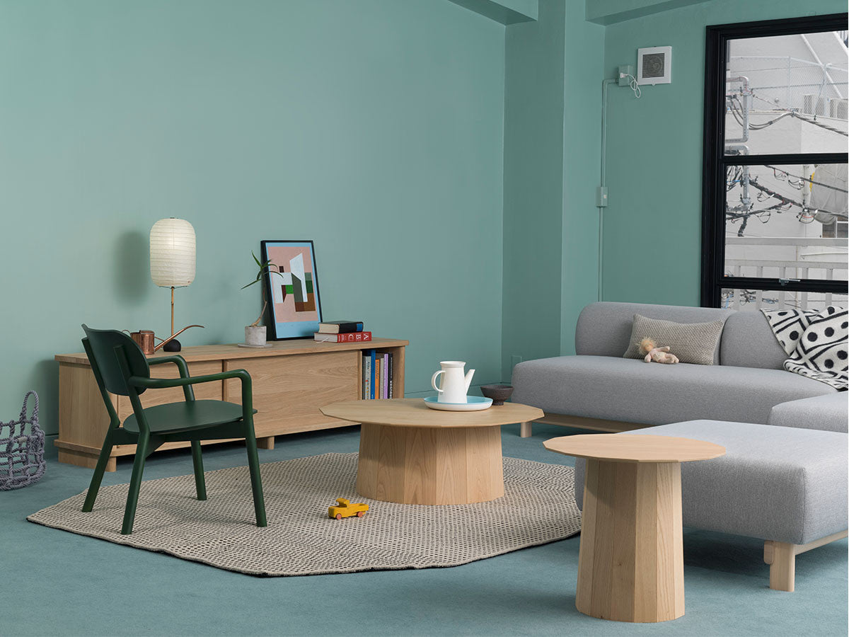 Sillón bajo Castor verde en un salón verde agua, con aparador y mesa baja redonda | Antifer