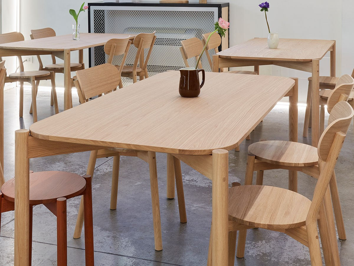Tische und Stühle Castor aus Eiche in einem Showroom, Hocker Castor Plus im Hintergrund | Antifer