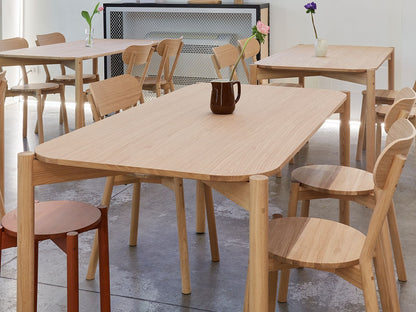 Tische und Stühle Castor aus Eiche in einem Showroom, Hocker Castor Plus im Hintergrund | Antifer