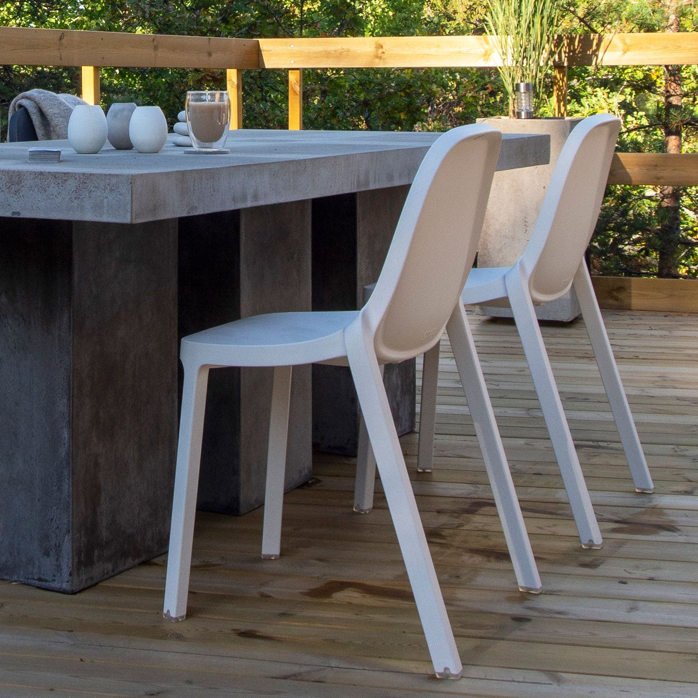 Terrasse. Gros plan sur table avec café & deux chaises Broom Emeco design Philippe Starck 