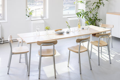 Salle à manger avec verres & chaises Emeco autour d'une table run en frêne.