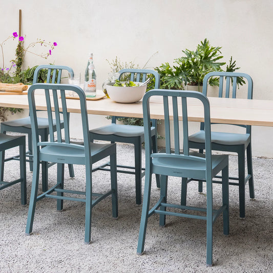 Patio terrasse extérieure aménagée avec chaises 111 Navy Emeco autour d'une grande table à manger.