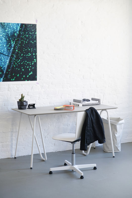 Bureau studio ultra blanc avec paire de tréteaux Sinus en acier courbé design minimaliste. couleur blanche. Vue de côté