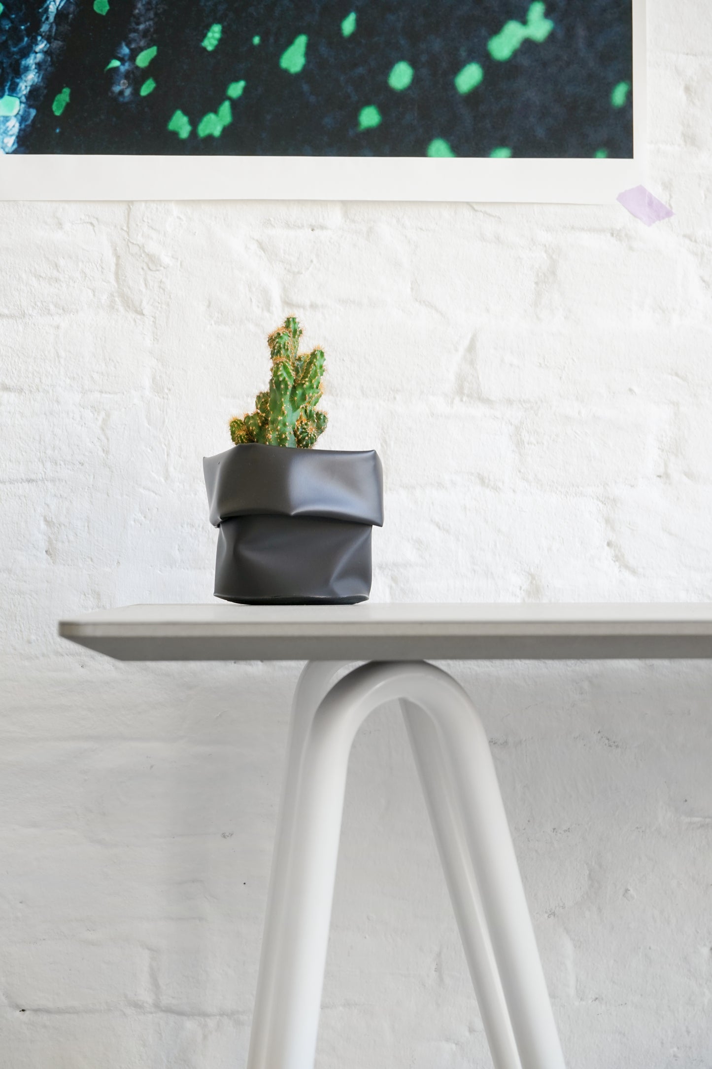 Gros plan sur haut tréteau Sinus en acier courbé couleur blanche. Autre côté de bureau