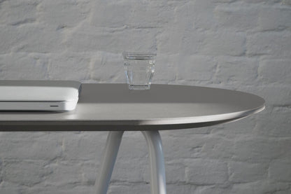 Gros plan sur petit bureau console minimaliste avec tréteaux Sinus avec verre d'eau et ordinateur