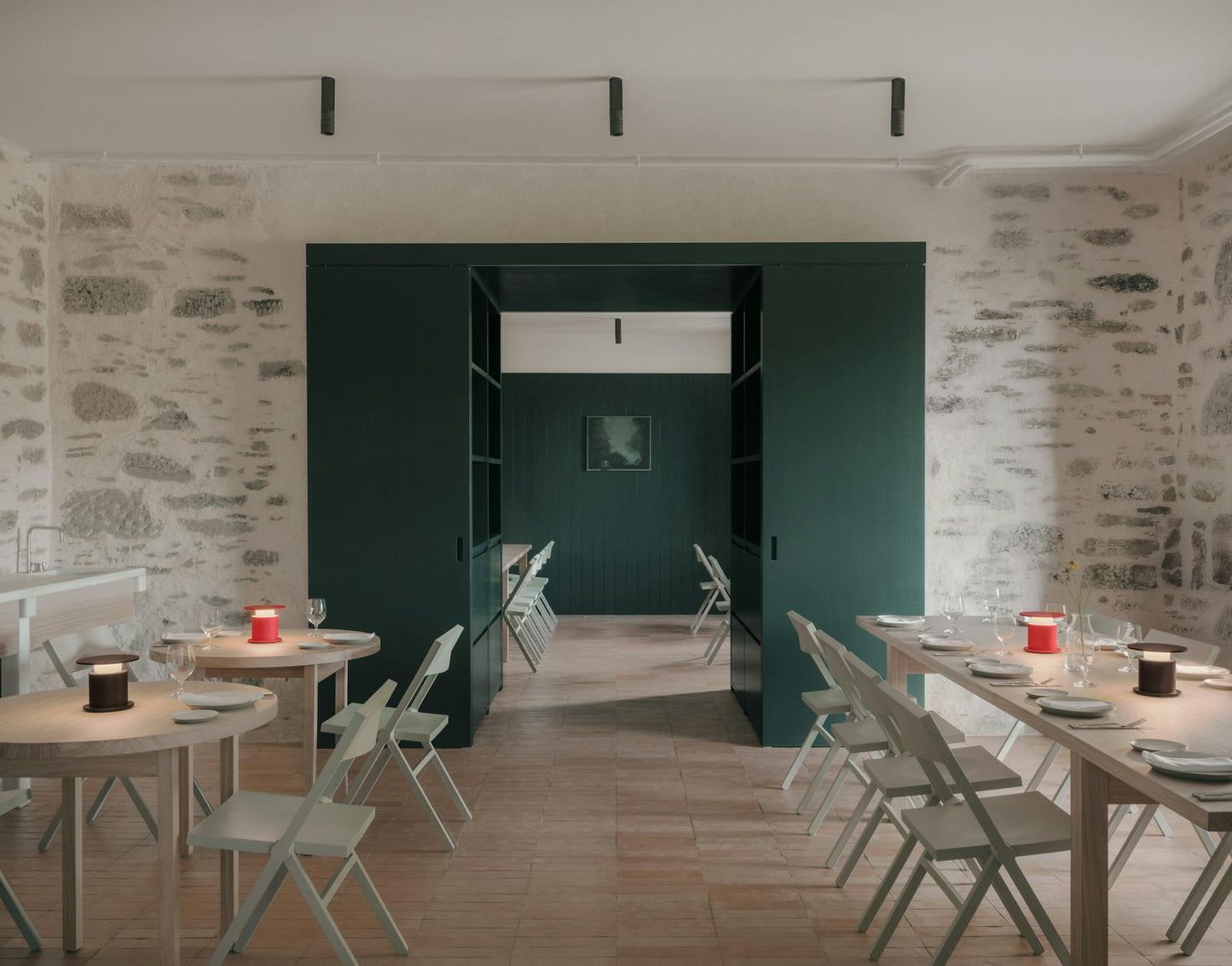 Lampes nomade w241 Faro rouge & chocolat posées sur plusieurs tables dans un restaurant. Wästberg. Design David Chipperfield