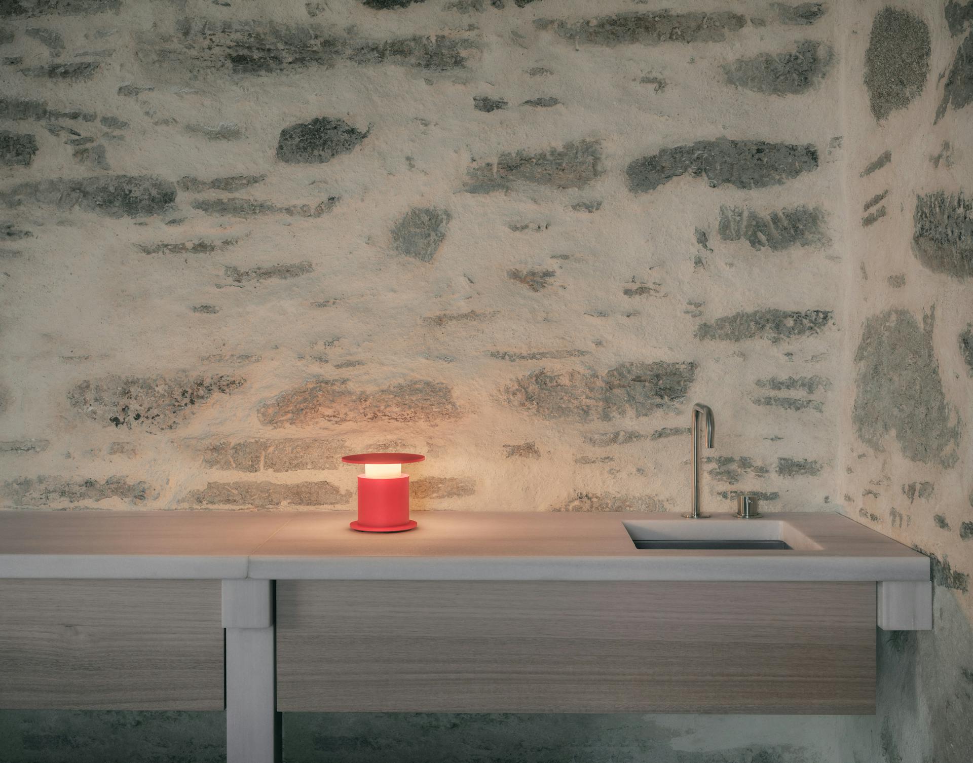 Lampe nomade w241 Faro rouge posée sur un plateau de cuisine. Wästberg. Design David Chipperfield