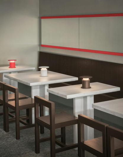 3 lampes nomades w241 Faro. WÄSTBERG. Design David Chipperfield.  posée sur des tables de restaurant