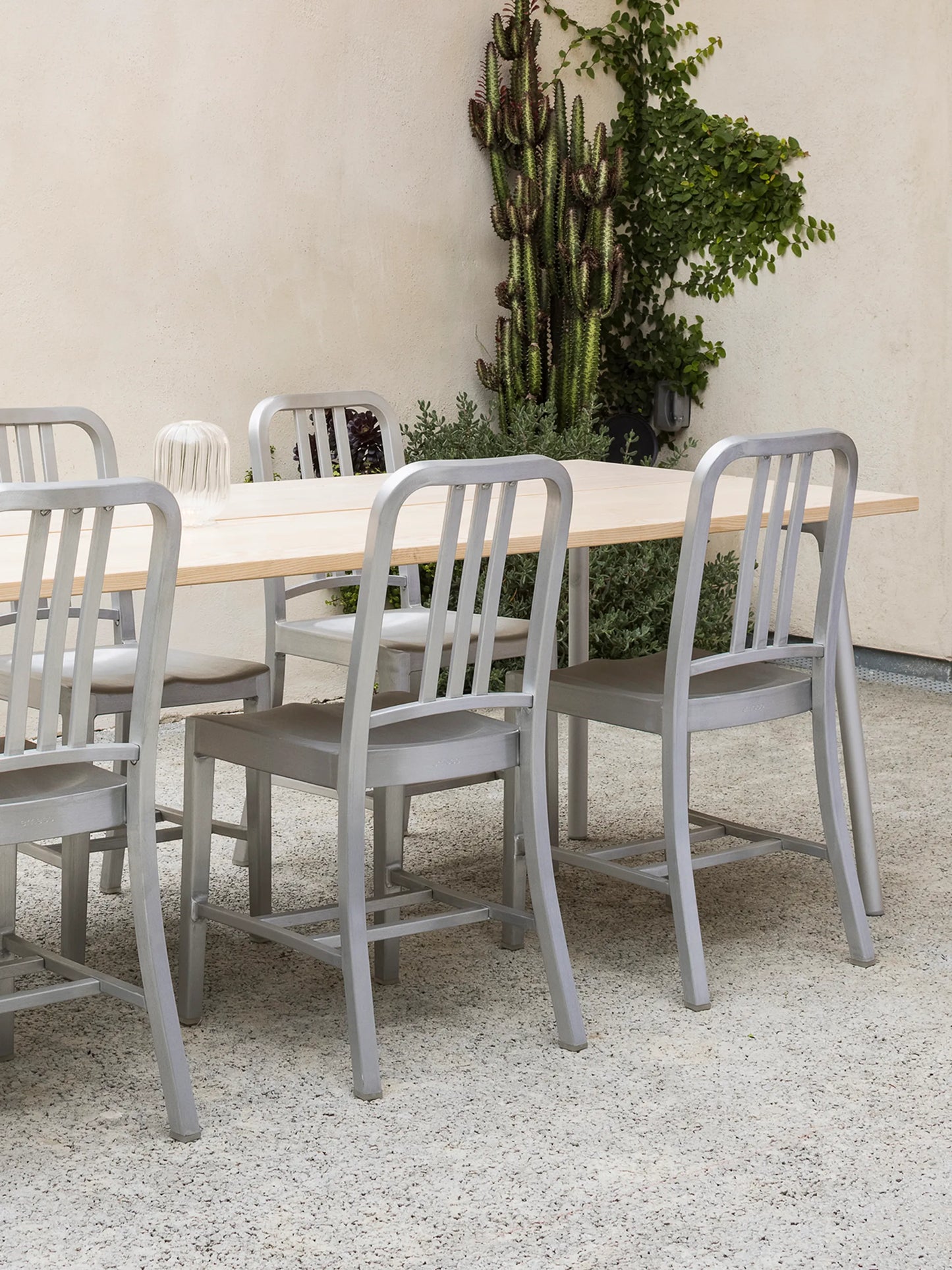 Patio Emeco House en extérieur. 4 chaises Emeco Navy aluminium brossé autour d'une table Run.